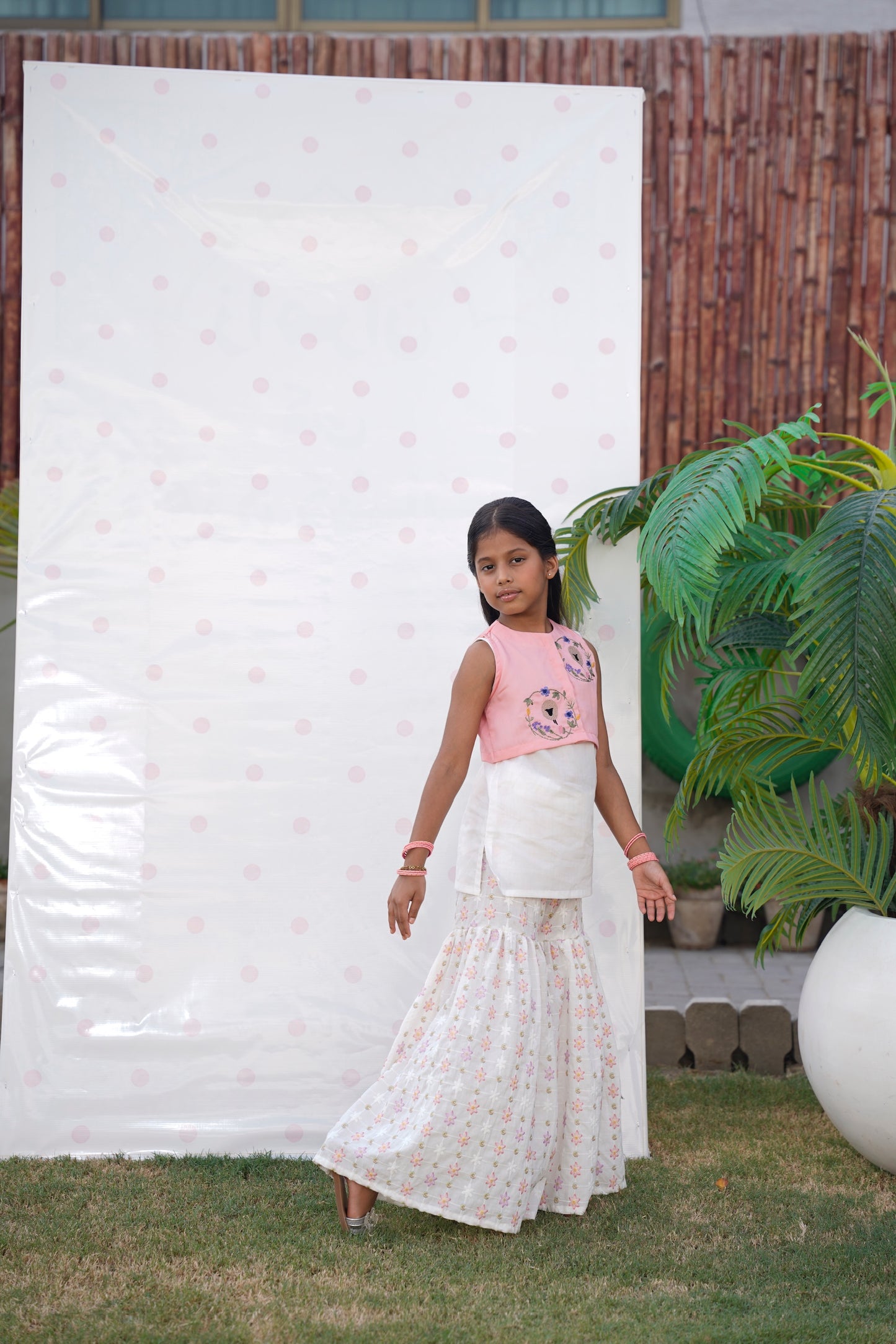 Full front, standing outdoors: "Blush pink embroidered cotton koti with floral chikankari gharara, full front view SHAFAÉ Goatie Blush"