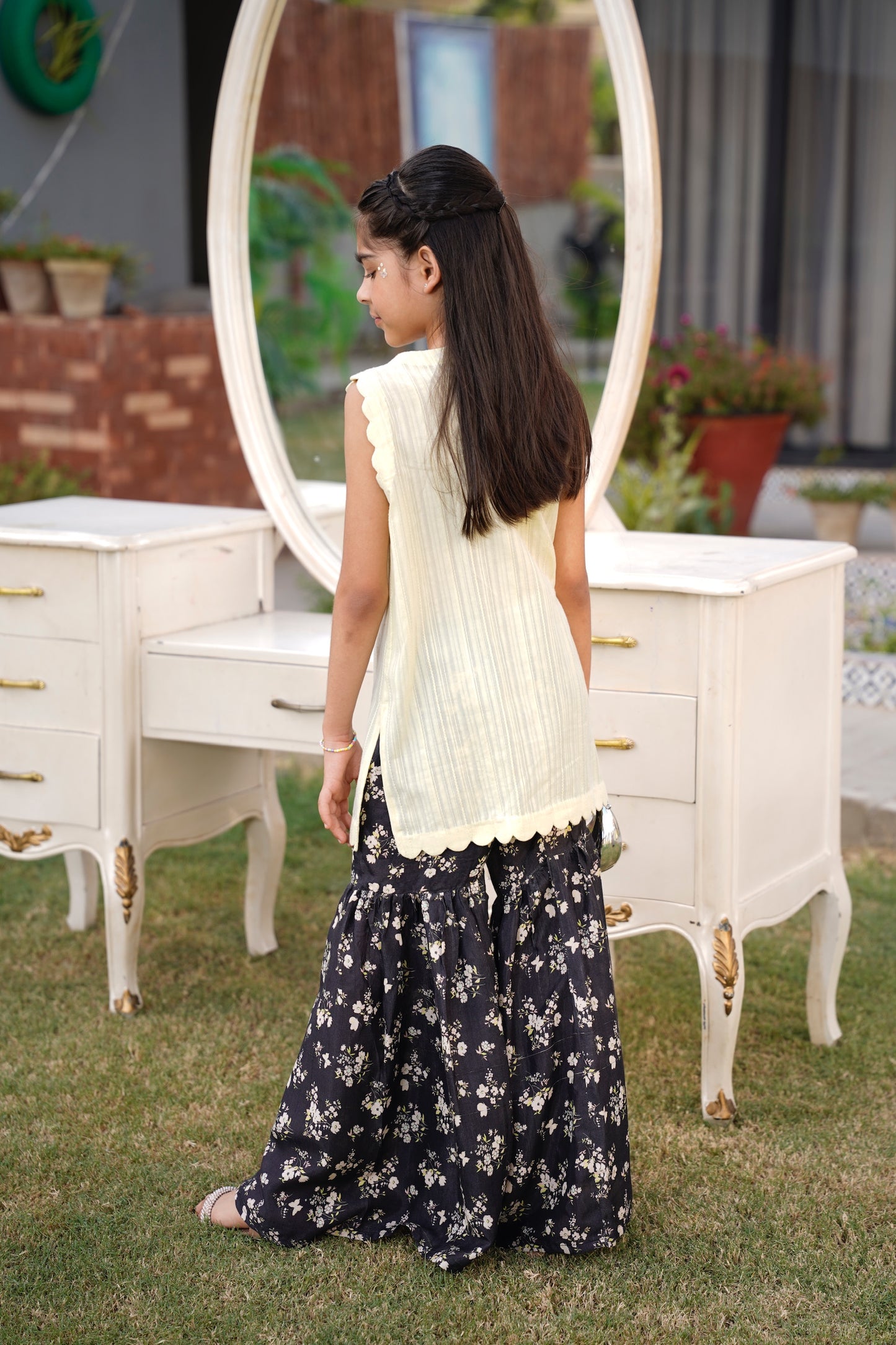 Full front, standing outdoors: "lemon lawn sleeveless shirt with dark floral printed gharara, full bank view SHAFAÉ lemon Bloom