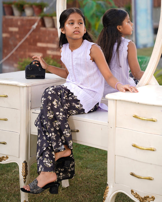 Full front, sitting outdoors: "Lemon lawn sleeveless shirt with dark floral printed gharara, full front view SHAFAÉ Lemon Bloom"