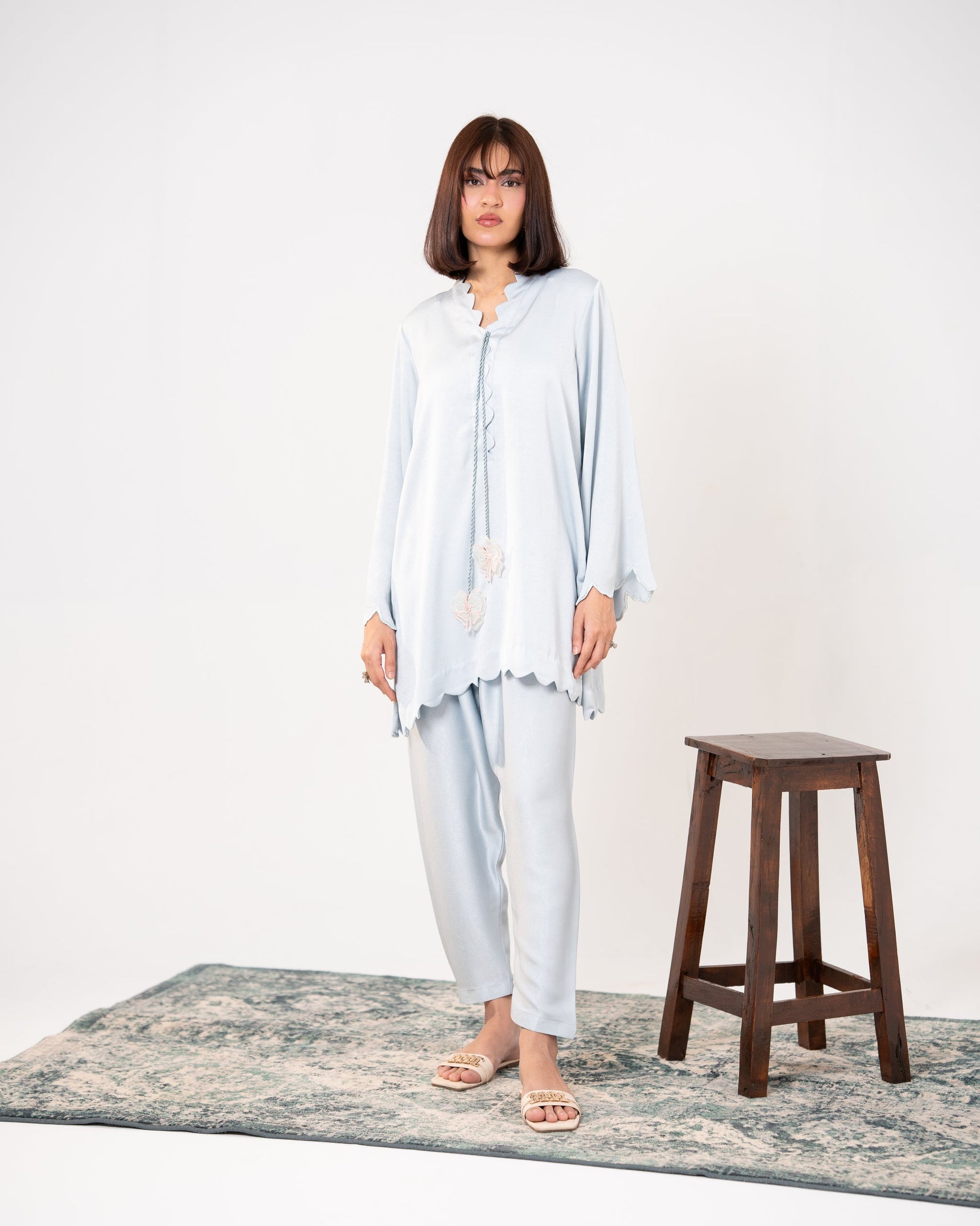 "Ice blue embroidered silk co-ord, full front view — SHAFAÉ Ice Blue Embroidered Co-Ord"
Seated front shot: "Ice blue silk co-ord with scalloped sleeves, seated pose — SHAFAÉ Ice Blue Embroidered 