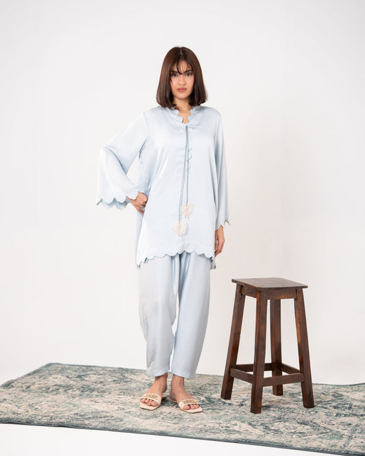 "Ice blue embroidered silk co-ord, full front view — SHAFAÉ Ice Blue Embroidered Co-Ord"
Seated front shot: "Ice blue silk co-ord with scalloped sleeves, seated pose — SHAFAÉ Ice Blue Embroidered"