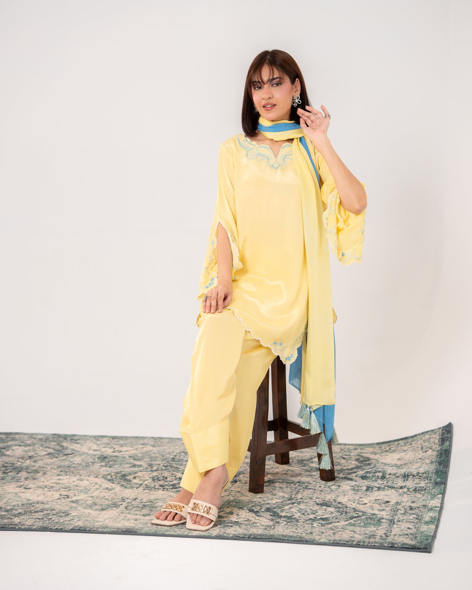 Woman in a yellow outfit sitting on a stool with a white background Butter Yellow Dreams embroided silk suit dress wth farshi shalwar and ombre dupatta Shafae