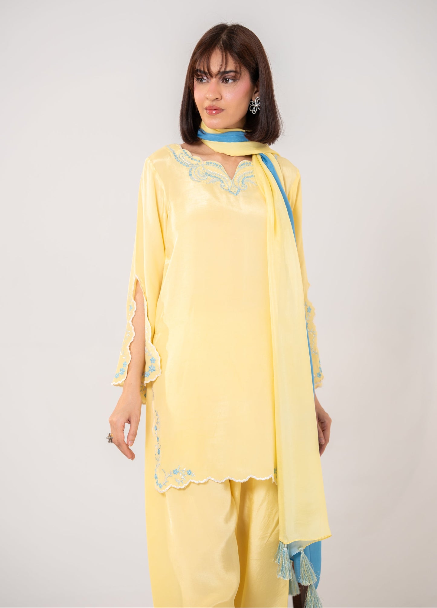 Woman wearing a yellow traditional outfit with blue accents on a white background Butter Yellow Dreams embroided silk suit dress wth farshi shalwar and ombre dupatta Shafae