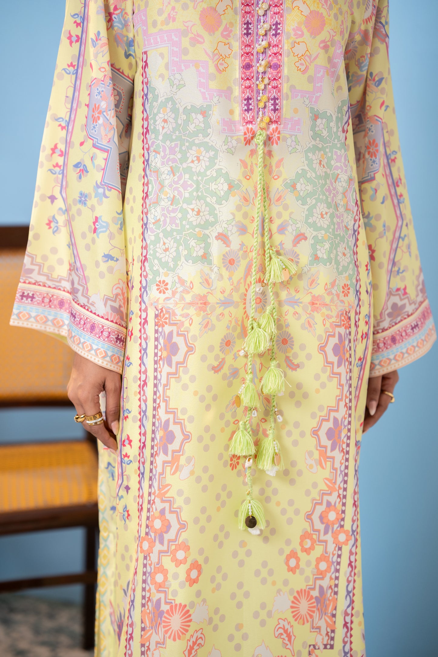  "Close-up of mint tasseled cord on pastel yellow printed silk kaftan SHAFAÉ Sunlit Kaftan"